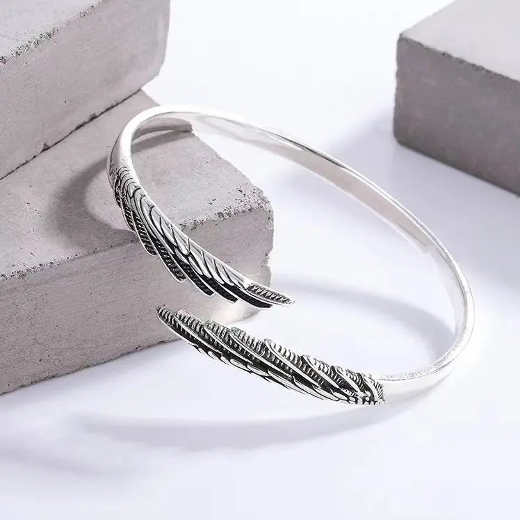 Silberfarbener Armreif mit Feder